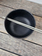 Black soup bowl with steel chopstick, white flower