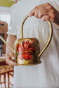 Golden metal watering can, white flower